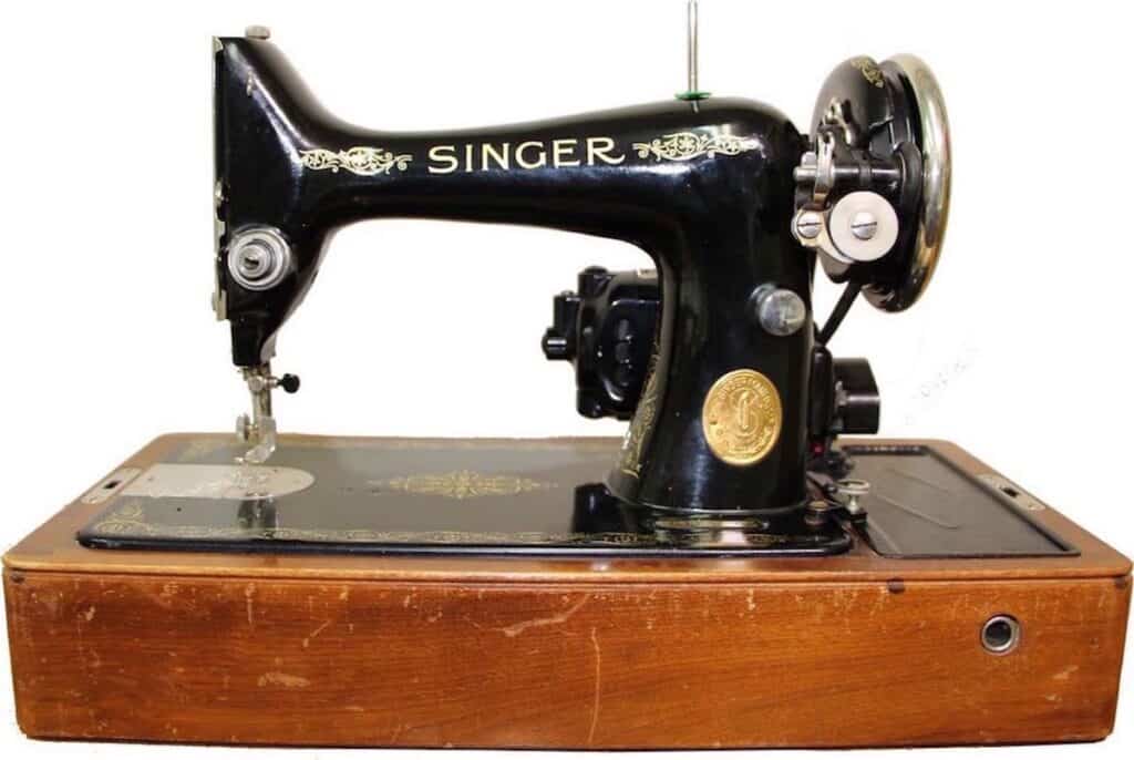 A vintage singer sewing machine atop a wooden box.