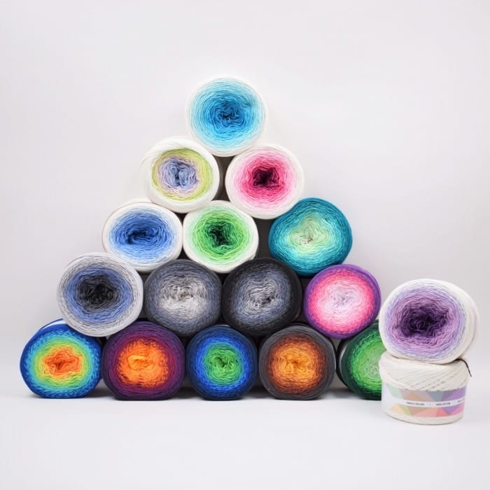 A stack of colorful yarns, perfect for DIY crochet shawl patterns, on a white background.