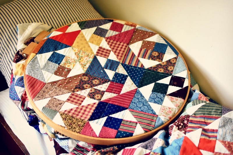 A quilted hoop on a bed in the Vibrant Quilting Tale of Emma and Lily.
